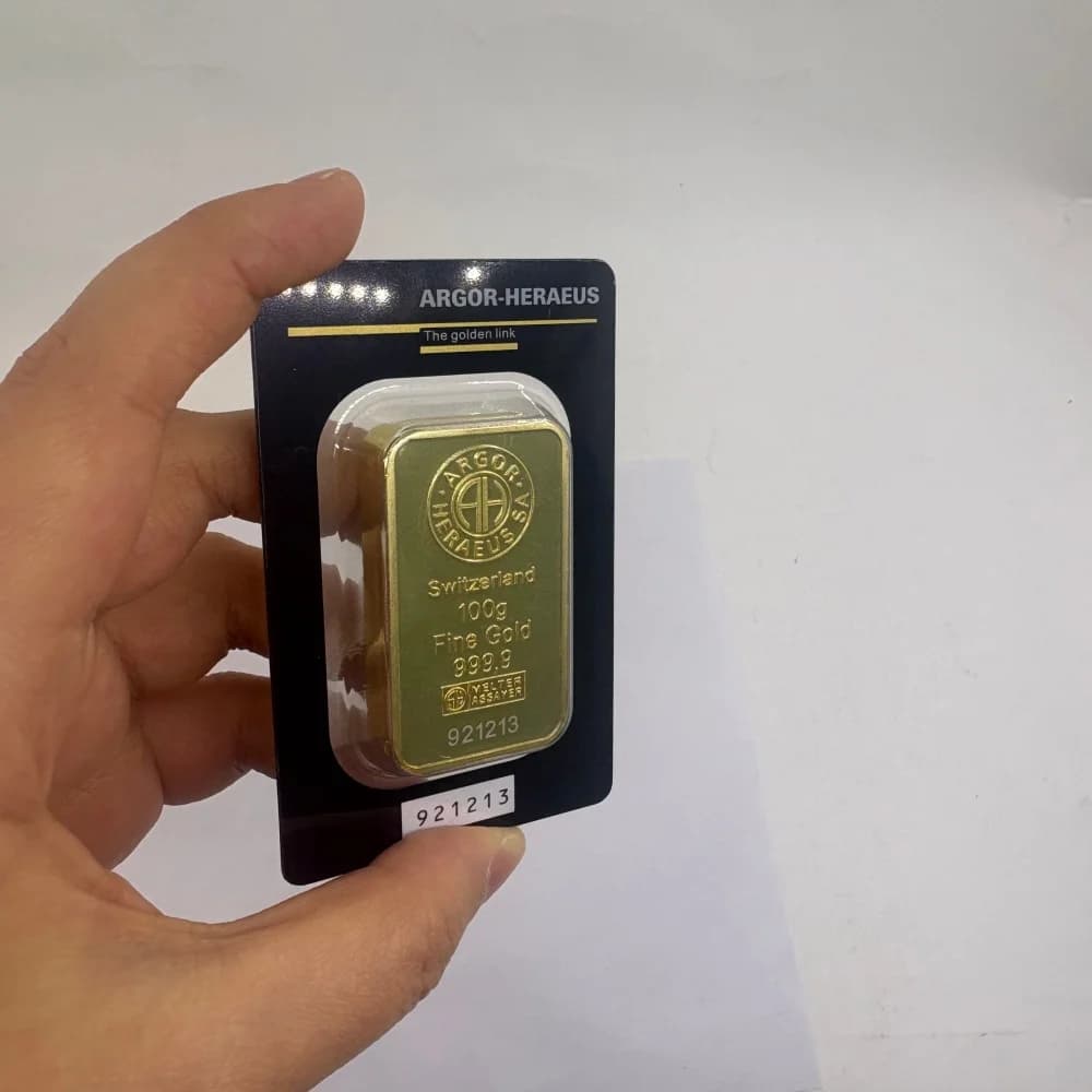 Nichtmagnetischer, vergoldeter Goldbarren von APMEX mit unterschiedlichen Seriennummern und versiegelter Verpackung für Sammler.